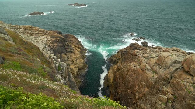 Detalle de un acantilado en la costa de A Coru&ntilde;a, con rocas escarpadas frente al oc&eacute;ano Atl&aacute;ntico y un paisaje litoral de gran fuerza natural.