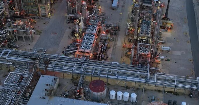 Aerial view of the Joliet oil refinery featuring complex industrial piping, cooling fans, storage tanks, and metallic structures in Joliet, Illinois, United States.
