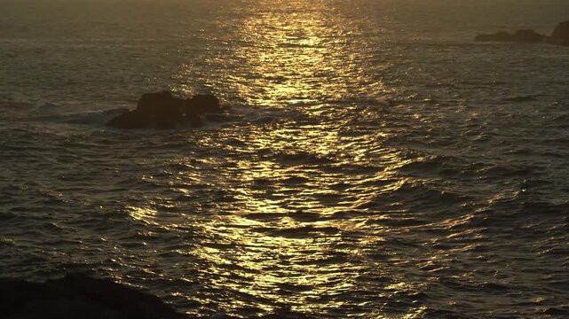 Detalle del reflejo del sol al atardecer sobre el oc&eacute;ano Atl&aacute;ntico, creando destellos dorados y tonos c&aacute;lidos sobre la superficie del mar.