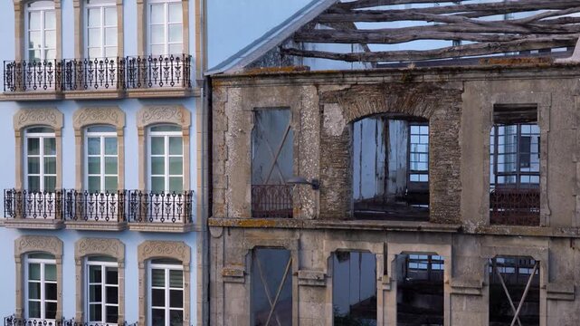 Contraste entre un edificio moderno y otro antiguo en estado de abandono y deterioro en la ciudad de Lugo.