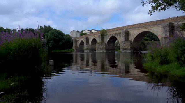 Vista general del puente romano de Lugo en un d&iacute;a nublado, sobre el r&iacute;o Mi&ntilde;o, mostrando su estructura hist&oacute;rica y el paisaje gallego.