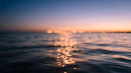 Fototapeta premium Sunset over calm ocean with golden reflections. Serene seascape featuring soft horizon glow and tranquil water surface.