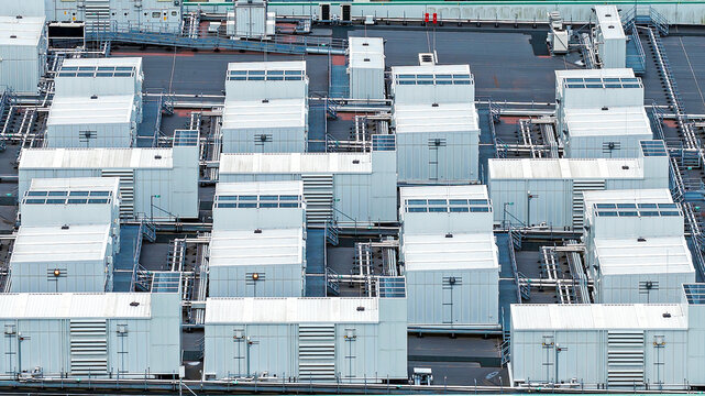 Aerial view of a large data center facility with rows of white cooling units and technical infrastructure on the roof in Middenmeer, North Holland, Netherlands.
