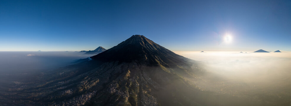 Aerial view of Nepal Van Java on the slopes of Mount Sumbing, featuring terraced agricultural fields and morning mist, Kecamatan Kaliangkrik, Jawa Tengah, Indonesia.
