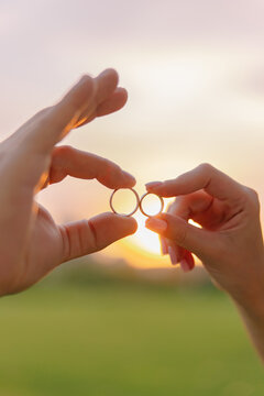 Bride Groom Hands Holding Wedding Rings At Sunset