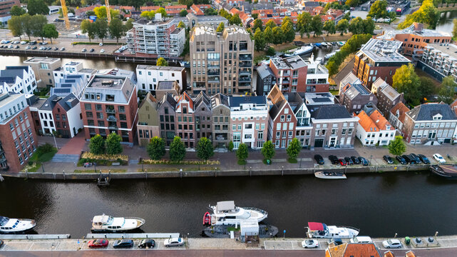 Aerial view of historic and modern buildings along the canal with moored boats and parked cars in Zwolle, Overijssel, Netherlands.
