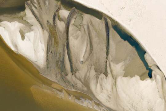 Aerial view of low water levels in a river revealing intricate sandbars and sediment patterns in Poland.