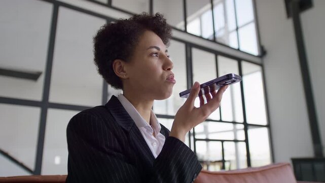 Businesswoman Recording Voice Message on Smartphone