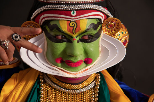 Kathakali dancer giving eye expressions with a smile on his face during a performance. 