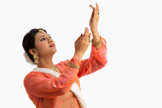 Beautiful kathak dancer performing over a white background. 