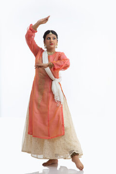 Kathak dancer giving a mesmerising performance in front of a white background. 