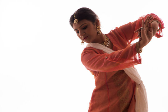 Graceful Kathak dancer giving a mesmerising performance in front of a white background. 