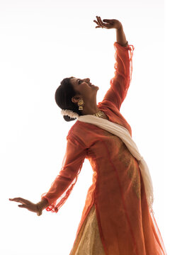 Graceful Kathak dancer giving a mesmerising performance in front of a white background. 