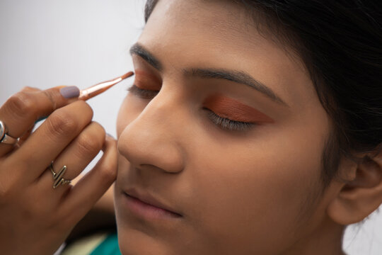 Kathak dancer getting makeup applied on her face. 