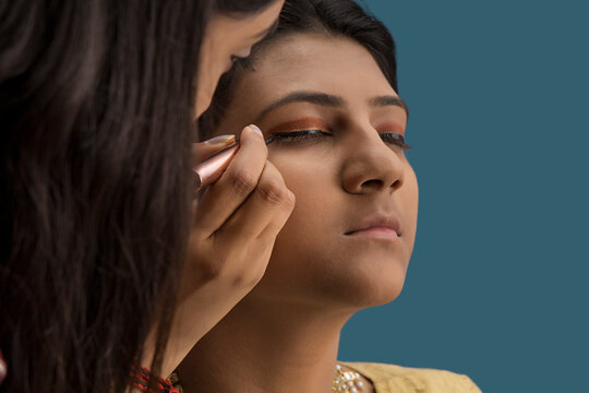 Makeup artist putting eyeliner on the kathak dancer�s eye. 