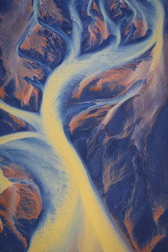 Aerial view of a braided glacial river delta with vibrant sediment patterns and winding channels in Selfoss, Sveitarfelagid Arborg, Iceland.