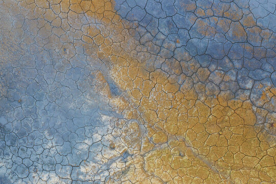 Aerial view of Hverir Sulfur Springs with vibrant orange and blue geothermal mud patterns and cracked earth, Reykjahlid, Thingeyjarsveit, Iceland.