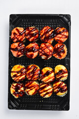 Large Japanese sushi roll set with salmon shrimp and unagi eel isolated on white background. Assorted rolls served in black takeaway tray. Fresh seafood. © Yaruniv-Studio