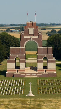 Aerial view of the Thiepval Memorial to the Missing of the Somme surrounded by a war cemetery with rows of graves and rural fields in Thiepval, Hauts-de-France, France.