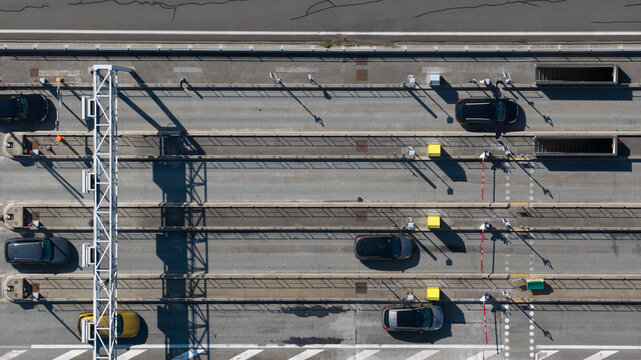 Aerial view of the Gare de Peage de Dury toll station with cars passing through lanes, overhead gantries, and road markings in Saleux, Hauts-de-France, France.