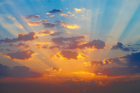 Picturesque  sunrise with golden rays of sun breaking through the dark clouds.