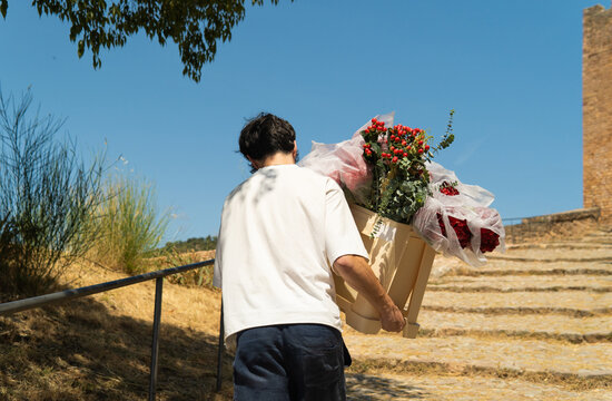 Man delivering flowers and gifts climbing stairs