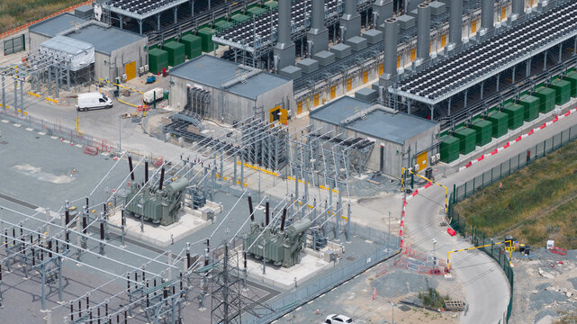 Aerial view of Thurrock Flexible Generation Substation featuring large transformers, electrical infrastructure, cooling units, and service roads in Tilbury, England, United Kingdom.