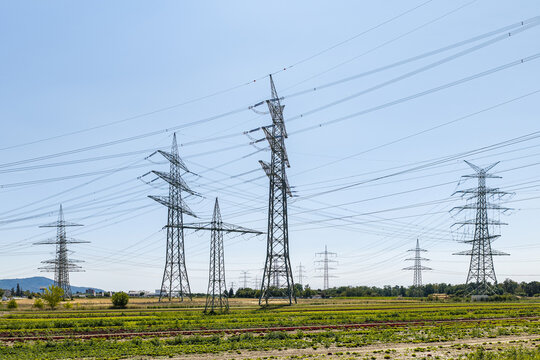 Aerial view of Amprion-Umspannwerk with high-voltage electricity pylons and power lines stretching across agricultural fields Pfungstadt, Hessen, Germany.