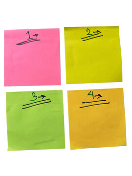 Four colorful sticky notes with handwritten text on square paper sheets for office reminders