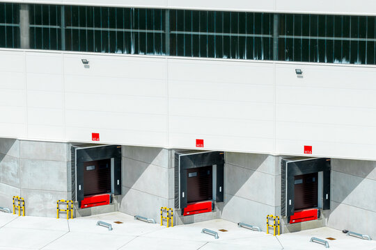 Aerial view of loading docks with red levelers and yellow safety bollards at a modern warehouse facility in Poland.