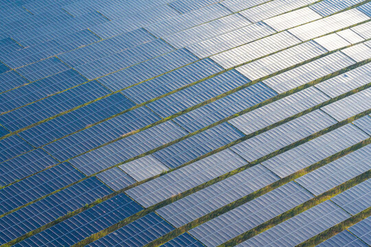 Aerial view of rows of photovoltaic solar panels arranged in a large field in Poland.