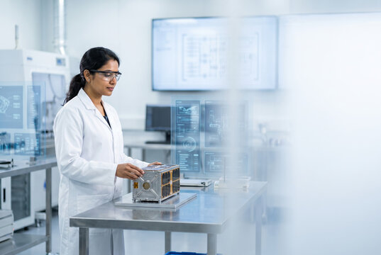 Indian female aerospace engineer examining a satellite component