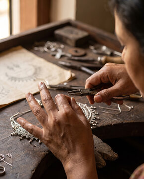 Indian jewelry artisan assembling a traditional silver necklace