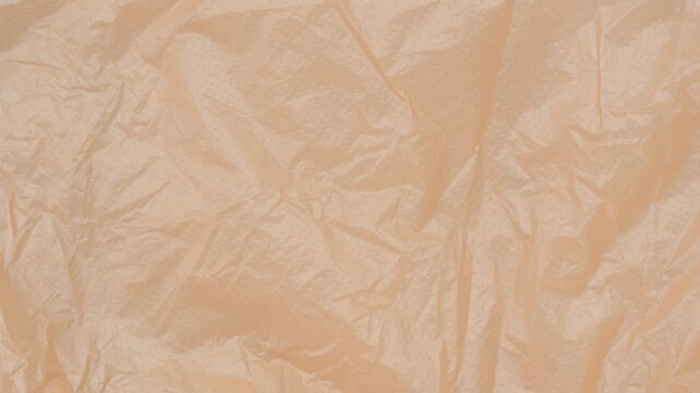Crumpled Peach Tissue Paper Shifts Across a Minimal Clean Surface, Creating a Seamless Abstract Background for Typography, Presentations, Overlays and Motion Graphics