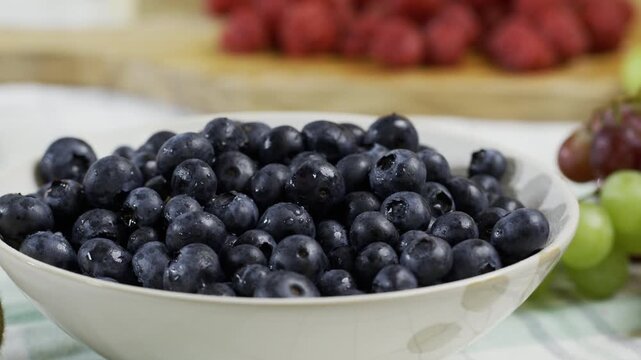 Cinematic tracking shot around bowl of fresh blueberries