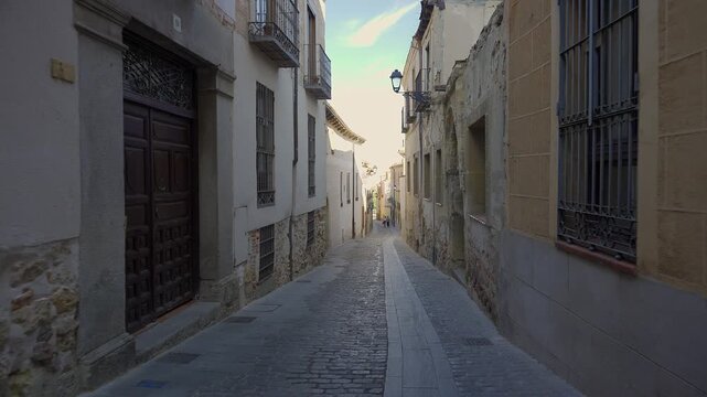 Historic alleyway with weathered facades and wrought balconies in the old Jewish Quarter of Segovia