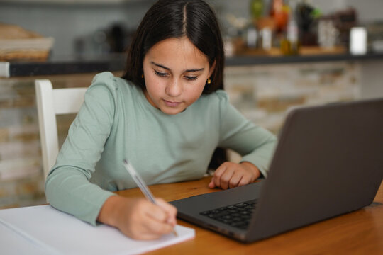 Young female child using laptop for tutoring private class - School, education and study concept
