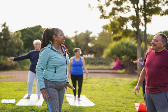 Happy multiracial senior people doing yoga class at city park - Fit healthy elderly group, sport and active lifestyle concept