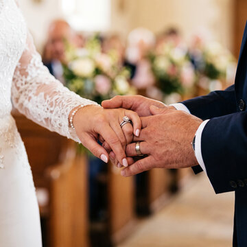 Bride and Grooms Hands Tenderly Exchanging Rings at the Wedding Ceremony