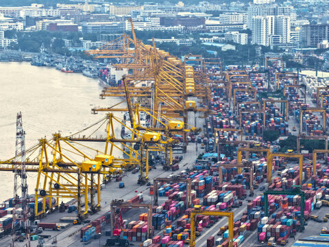 Aerial view of the busy Chattogram Port featuring numerous yellow gantry cranes and rows of colorful shipping containers along the waterfront in Chittagong, Chittagong Division, Bangladesh.