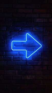 Bright blue neon arrow glows against a dark brick wall