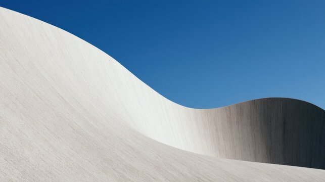 Minimalist concrete waves and curved modern architecture under a clear blue sky