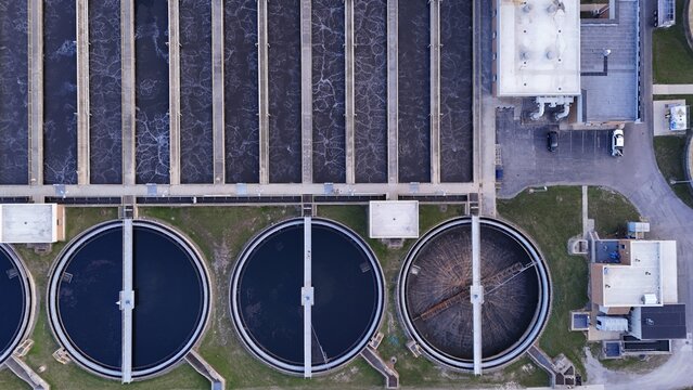 Aerial view of the rural water treatment facility featuring large circular sedimentation tanks and rectangular aeration basins in Monroe, Michigan, United States.