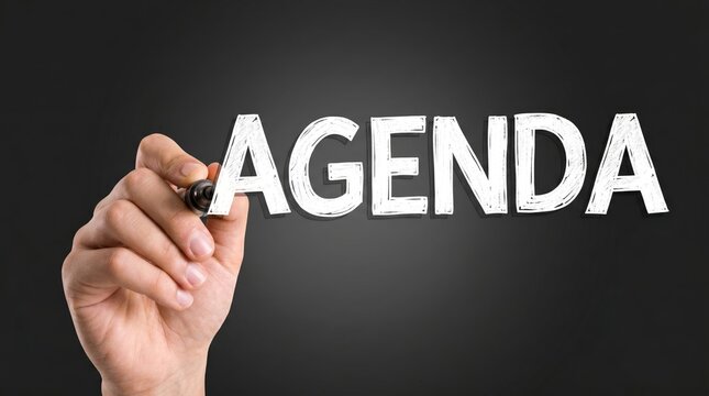 Hand writing agenda on dark background with marker for planning with distressed letters marker against dark emphasizing focus organization word agenda bold