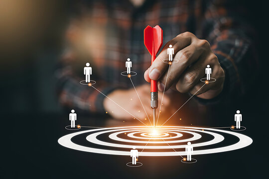 Business success concept with hand holding red dart aiming at target with team human icons business strategy marketing leadership management corporate planning development connection