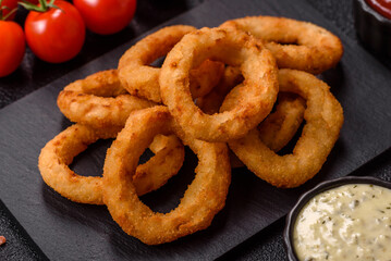 Naklejka premium Deep fried breaded onion or squid rings, crispy fast food snacks. Fried onion or squid rings