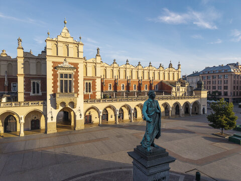 Aerial view of the historic Sukiennice Cloth Hall in the Main Market Square with its Renaissance architecture, stone arches, and a statue in Krakow, Malopolskie, Poland.