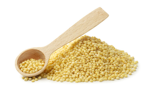 Pile of raw millet and a wooden spoon in close-up on a white background. Isolated
