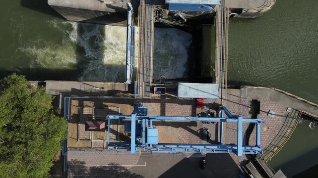 Aerial view of the blue metal sluice gate structure and surrounding water infrastructure in Banyumas Regency, Central Java, Indonesia.