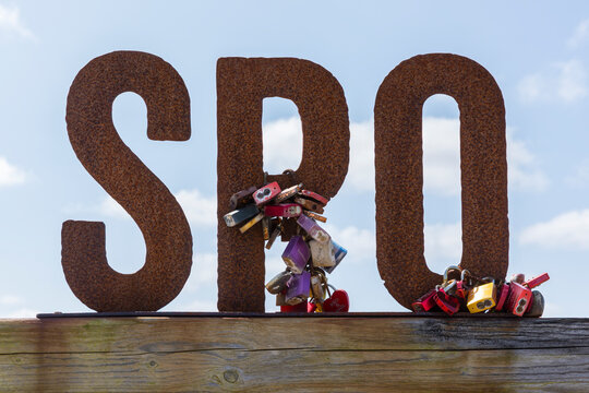 Sankt Peter-Ording, Germany &ndash; Love locks on rusty iron letters SPO, common abbreviation for the town's name.  the sign is located near the beginning of the boardwalk to the beach.